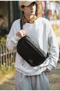 Détail du sac bandoulière en nylon noir avec logo blanc et sangle ajustable