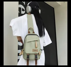 Rear view of a light green nylon mini backpack worn by a model in a minimalist setting