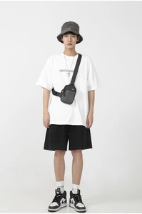 Detail view of a black oxford fabric crossbody bag shown on a model in a minimal style