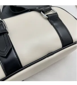 Close-up of black and white Boston bag showing the MuonShark embossed logo and PU leather texture