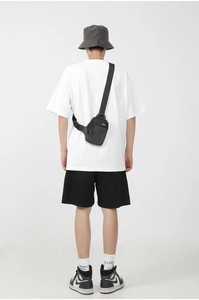 Rear view of model wearing a black nylon mini crossbody chest bag for casual styling