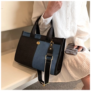 Detailed close-up of a blue denim patchwork tote bag with a golden turn-lock closure