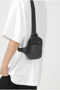 Detail showing side view of black oxford fabric crossbody bag on model with idyn logo