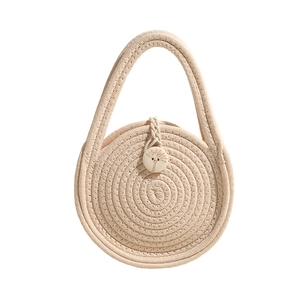 Minimalist round woven cotton rope handbag with engraved wooden button closure