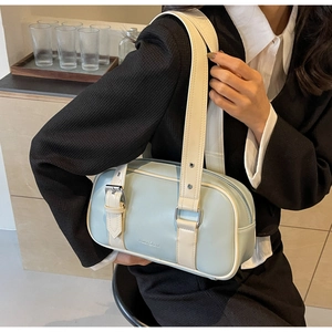 Detail of light blue and cream bowling bag featuring metal buckle and brand logo
