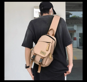 Detail of a beige nylon crossbody chest bag with adjustable straps and front pocket