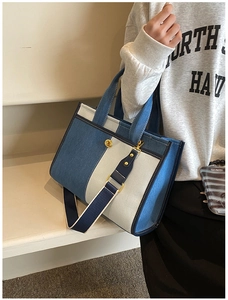 Detail of multi-color denim tote bag with striped shoulder strap and metal hardware