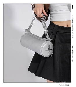 Detail of silver barrel bag with lychee texture leather and metallic star charm decoration