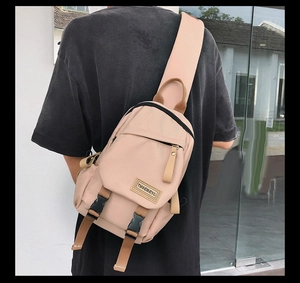 Detail showing the light pink nylon backpack worn on back with brown straps and buckles