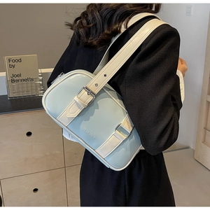 Detail view of MoonShark mint blue and white PU leather shoulder bag on model shoulder
