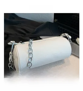 Close-up of white cylindrical PU leather bag with lychee texture and silver chain strap