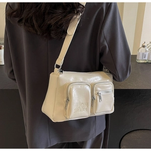 Detailed close-up of beige PU leather crossbody bag featuring 3D pockets and embossed logo