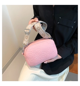Pink PU crossbody bag featuring rose embossed texture and ethnic style woven strap detail