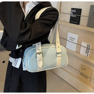Detail view of light blue and cream PU leather shoulder bag with adjustable metal buckle
