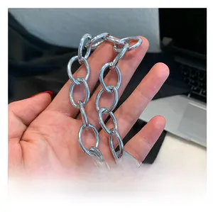 Detail of the thick polished silver metal chain link handle on the PU handbag