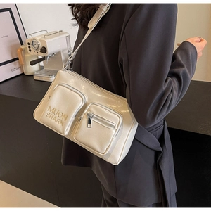 Detail view of cream white PU leather crossbody bag with dual pockets and MUON SHARK embroidery