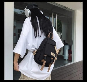Detail of a nylon chest bag with khaki straps and buckle pocket in a street style look