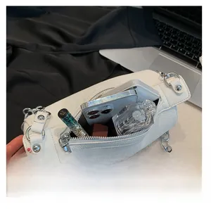 Internal view of white cylinder bag showing storage capacity for phone and cosmetics