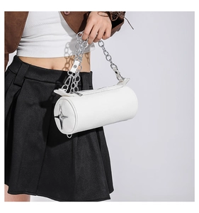 Close-up of white PU leather cylinder bag with silver star detail and metal chain