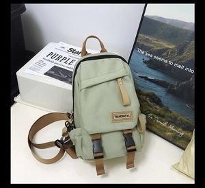 Close-up of mint green nylon backpack with brown straps and buckle closure details
