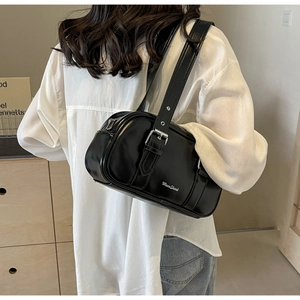 Detail of black glossy PU shoulder bag with silver buckle and MuanShark logo
