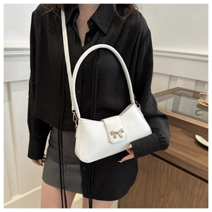 Détail du sac à bandoulière blanc en similicuir avec boucle nœud doré et deux sangles