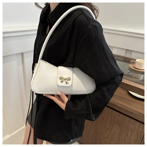 Gros plan du sac à bandoulière en cuir PU blanc avec boucle décorative en nœud doré