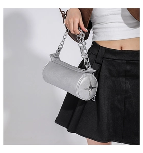 Silver cylindrical handbag with litchi texture and metal chain on a fashion model