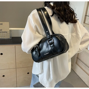 Detail of a chic black cylinder PU leather shoulder bag with white printed logo lettering