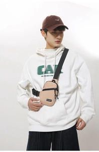 Detail of khaki nylon chest bag showing adjustable black strap and buckle on model