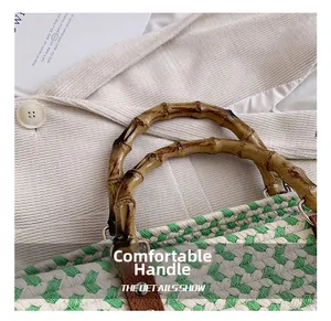 Detail of woven handbag featuring green fiber patterns and natural bamboo top handle