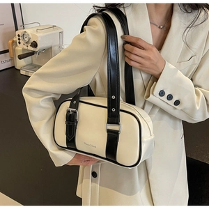 Detail of a minimalist cream PU leather shoulder bag with black strap and MuonShark logo