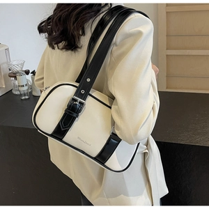 Side view of cream PU shoulder bag with black contrast straps on a beige blazer