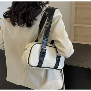 Model wearing a white PU leather underarm bag with black trim and metal buckle details