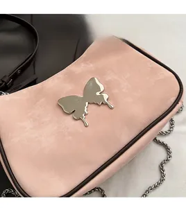 Gros plan du sac rose mat avec ornement papillon en métal argenté effet liquide