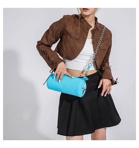 Detail of bright blue PU leather cylinder bag with silver star charm and chain strap