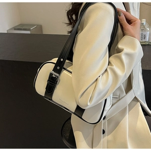 Detail view of cream PU leather handbag with black contrast trim and adjustable strap