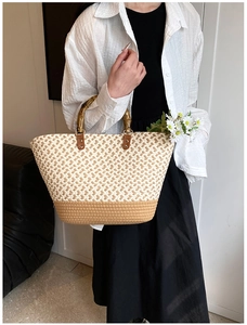Detail view of woven tote bag showing bamboo handles and intricate geometric patterns