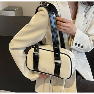 Detail of white PU leather shoulder bag with black trim and silver buckle accents
