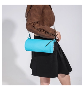 Close-up of bright blue cylinder PU shoulder bag with fine metal chain and side accents