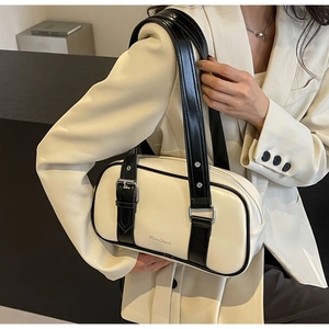 Detail of minimalist cream PU leather tote bag with black contrast straps and silver buckles