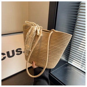 Handwoven rope tote bag in light brown featuring elegant lace ribbon bow decoration