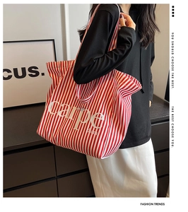 Detail of red and white striped canvas tote bag with Carpe Diem text for casual style
