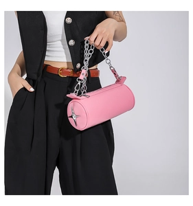 Detailed macro view of pink cylinder PU leather bag with silver chain and metal star charm