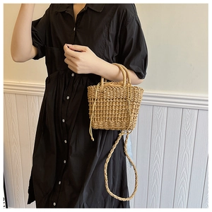 Detail showing handwoven straw texture and adjustable crossbody strap on the beige tote bag