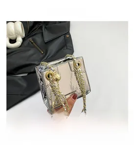Detail of silver metallic box bag with gold chain strap and basketball pendant