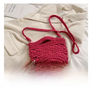 Detail shot of the handmade magenta crochet knit bag with thick texture and long strap