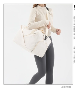 Detailed view of off-white large nylon sports bag with functional zippers and strap