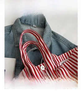 Detailed close-up of comfortable handle on red and white striped canvas tote bag