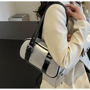 Detail showing the metallic silver barrel bag with black leather straps and embossed logo